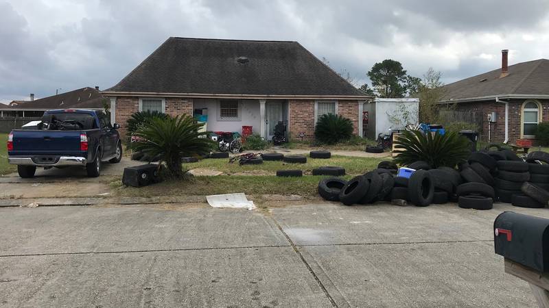 Dozens of old tires litter front lawn of New Orleans East home.
