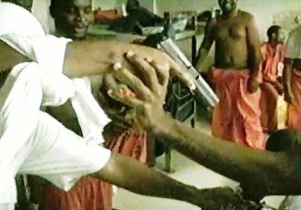 A still image from one of the videos, showing inmates playing with an apparently loaded...
